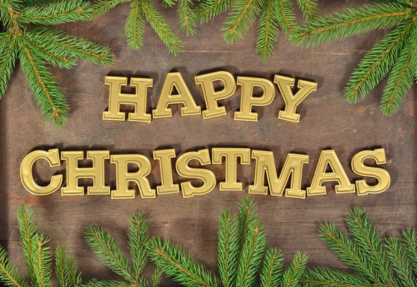 Feliz Navidad texto de oro y una rama de abeto
 - Foto, imagen