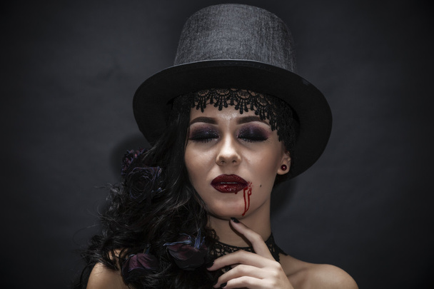 Portret van een prachtige brunette met een hoed op zwarte achtergrond - Foto, afbeelding