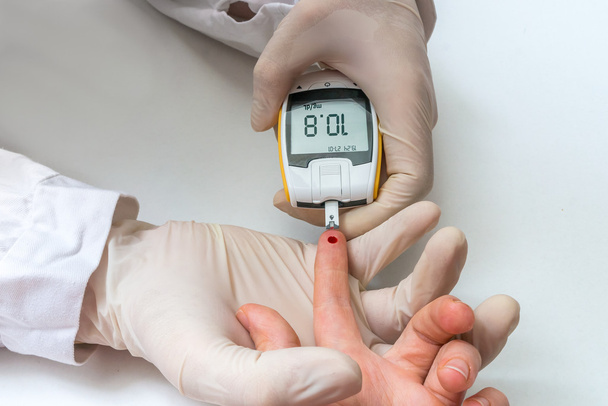 Dokter is het testen van bloed van de patiënt voor glucose en suiker. Diabetes concept. - Foto, afbeelding