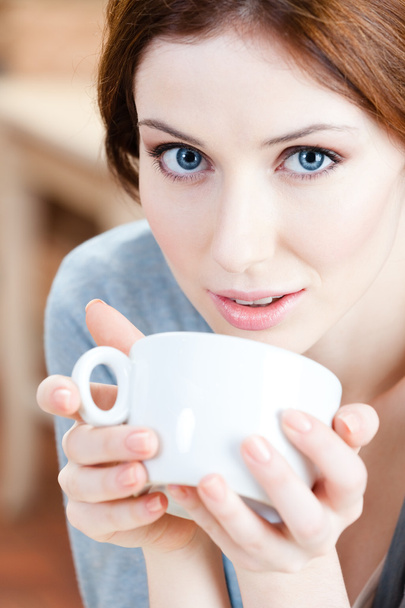 Blue-eyed woman with cup of tea - Zdjęcie, obraz