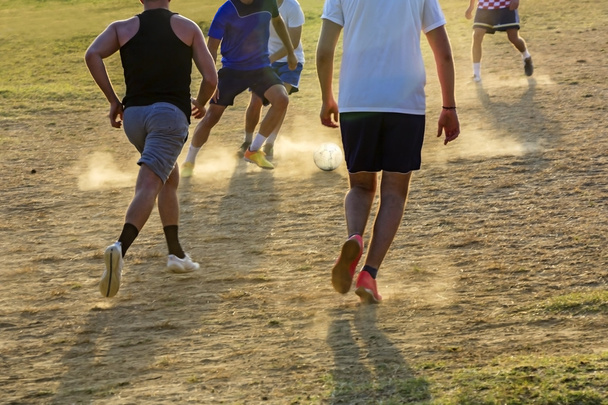 Jonge jongens spelen van de voetbalwedstrijd op de zonsondergang - Foto, afbeelding