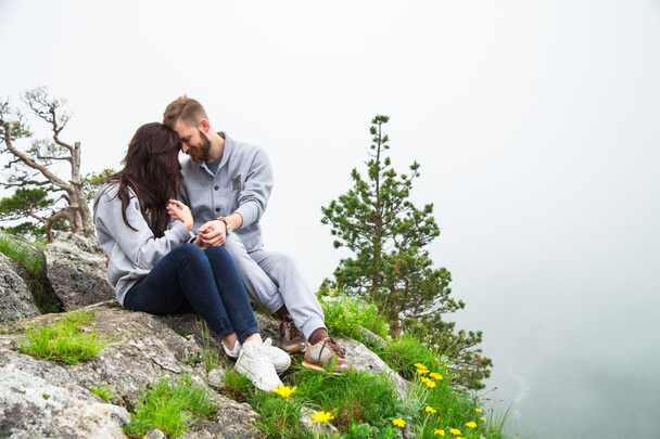 Happy young couple in love sitting on a mountain, hugging and lo - Foto, immagini