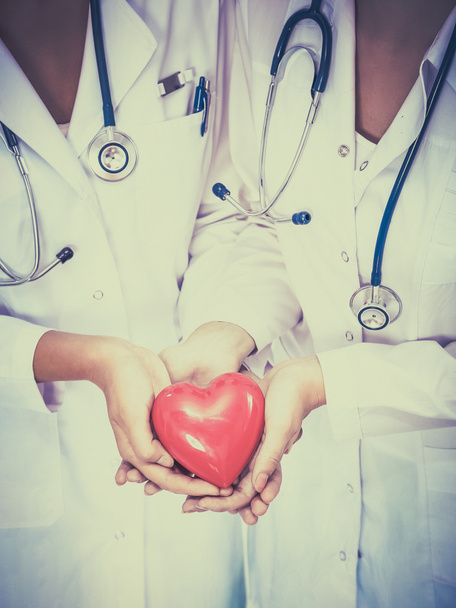 Dwie kobiety lekarz trzymając czerwone serce - Zdjęcie, obraz