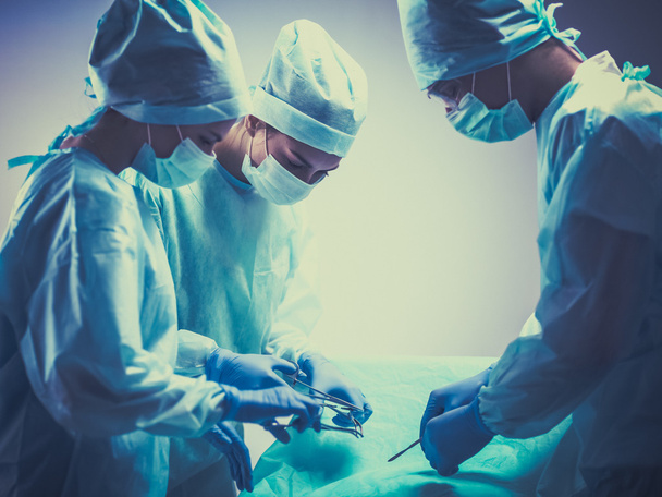 Командный хирург за работой в операционной - Фото, изображение