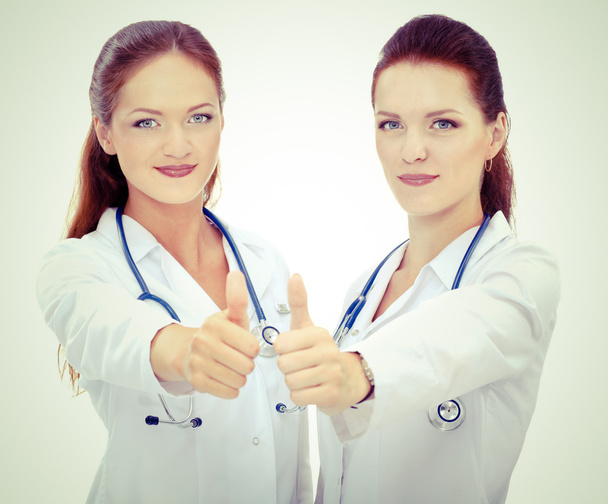 Two young woman doctor showing ok , standing in hospital - Фото, изображение