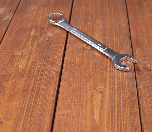Wrench chrome metal spanner instrument on wooden surface - Foto, Bild