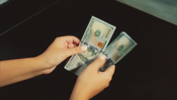 Vrouw handen tellen een pack van dollars op de zwarte achtergrond - Video
