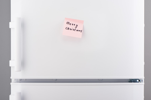 Merry Christmas note on pink sticky paper on white refrigerator  - Zdjęcie, obraz