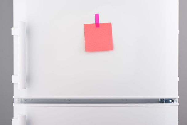 Blank pink paper note and pink sticker on white refrigerator - Photo, Image