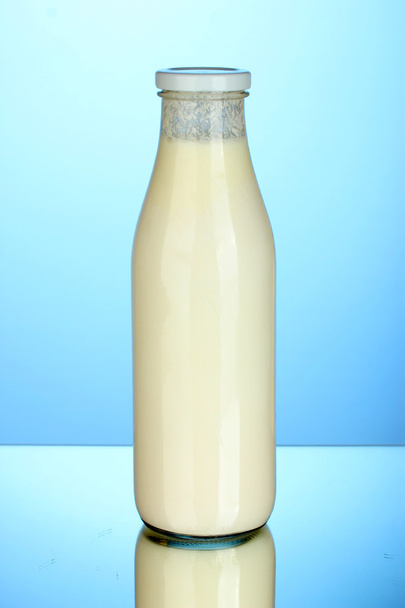 bottle of milk on blue background close-up - Fotó, kép