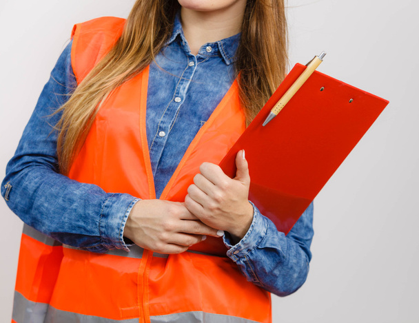 Woman engineer construction builder holds file pad. - Foto, afbeelding