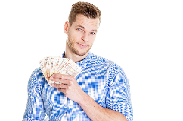 Portrait of smiling young man holding Euro paper currency isolat - Foto, imagen