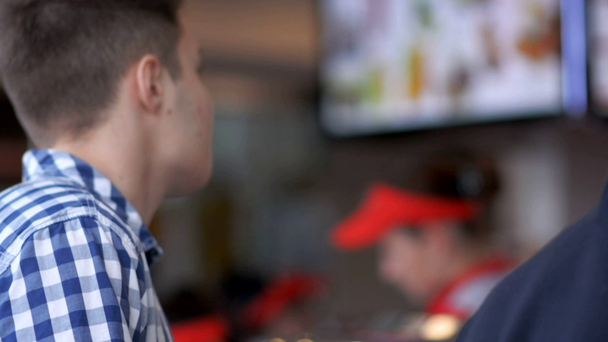 Hombre comprando comida rápida en el restaurante de comida rápida
 - Metraje, vídeo