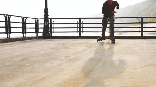 Mans legs roller skating inline close up on the asphalt sunset - Footage, Video