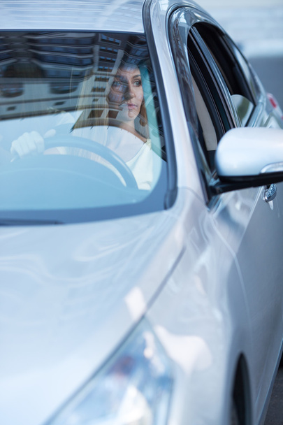 young adult blonde woman driving a car - 写真・画像