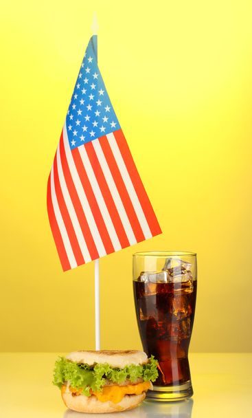 tasty sandwich and cola with american flag, on yellow background - Zdjęcie, obraz