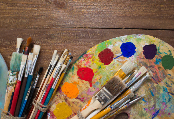 Paints, brushes and palette on the wood background.  - 写真・画像