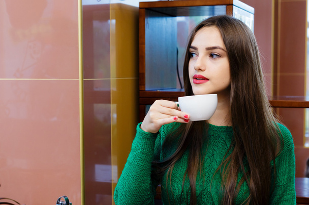 Красивая молодая женщина пьет чай в кафе
 - Фото, изображение