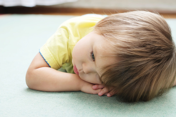 sulky little girl lying on the cover - 写真・画像