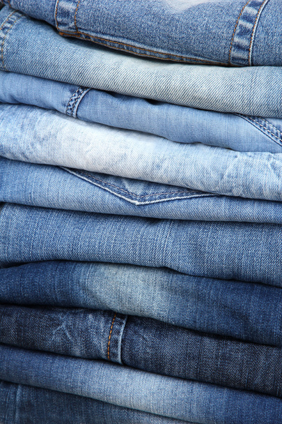 Many jeans stacked in a pile closeup - Zdjęcie, obraz