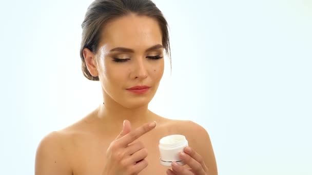 Chica aplicando crema hidratante en la cara. Movimiento lento
. - Imágenes, Vídeo