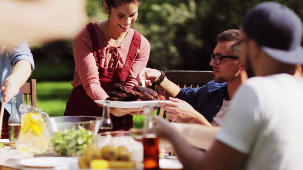 onnellisia ystäviä syömässä kesäpuutarhajuhlissa
 - Materiaali, video