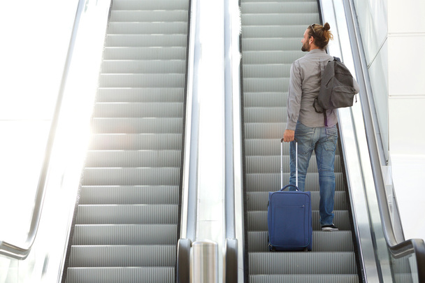 Traveling man going up escalator  - Photo, Image