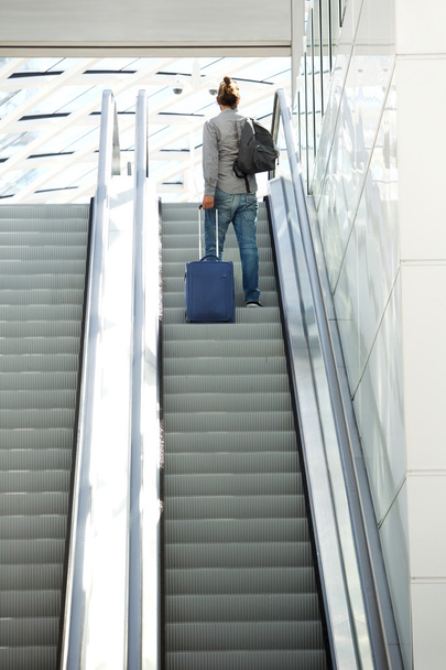 Homme debout sur l'escalator avec des sacs de voyage
 - Photo, image