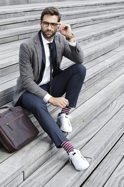 Handsome businessman sitting on staircase - Foto, Bild