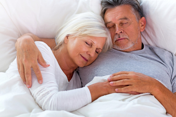 Senior couple lying in bed together - Fotó, kép