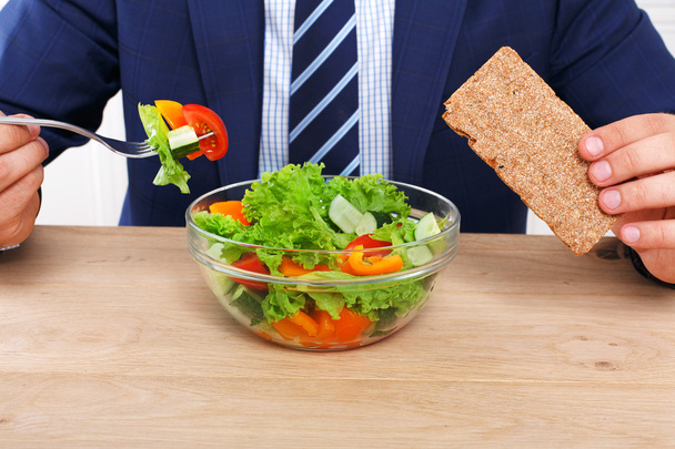 Uomo irriconoscibile ha pranzo di lavoro sano in ufficio moderno
 - Foto, immagini