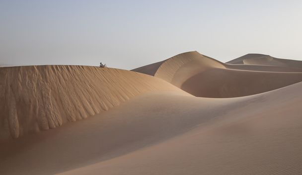 Homme en kandura dans un désert au lever du soleil
 - Photo, image