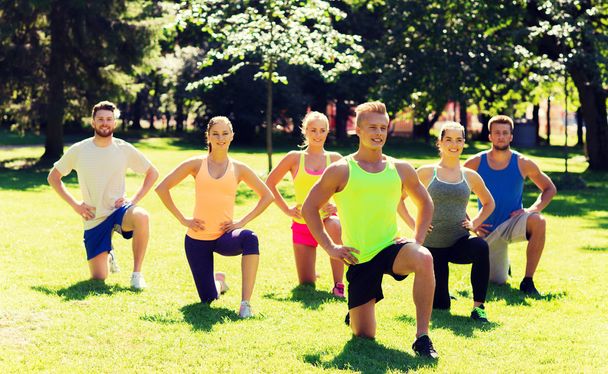 group of friends or sportsmen exercising outdoors - Foto, Imagen