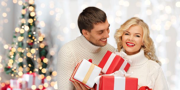 happy couple in sweaters holding christmas gifts - Фото, зображення