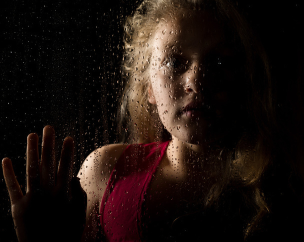 lonely young sad girl behind the window with drops - Valokuva, kuva
