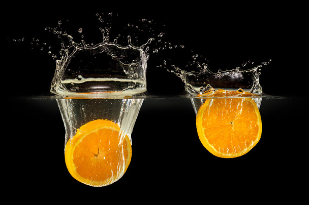 Group of fresh fruits falling in water with splash on black background - Foto, immagini