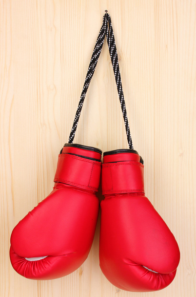 Red boxing gloves hanging on wooden background - Φωτογραφία, εικόνα