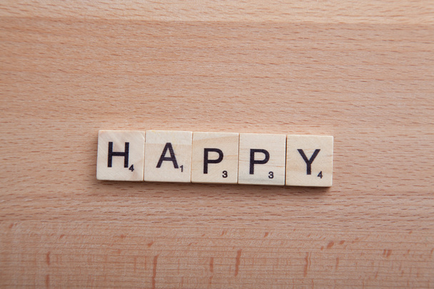Scrabble letters spelling the word happy. - Фото, изображение