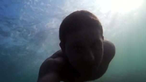Mies ui veden alla. Go-Pro video. Ihminen syöksyy mereen. Sukellus, mies sukeltaa ja ui veden alla. Sukellusta Mustallamerellä. Merijalkaväen sukellus, aktiivinen, kirkas vaikutelmia
.  - Materiaali, video