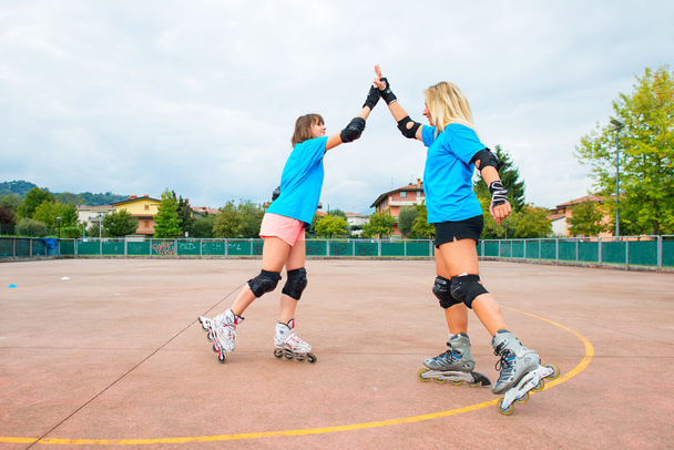 Two sports girl in a tennis Rollerblade give you clap their hand - Photo, Image