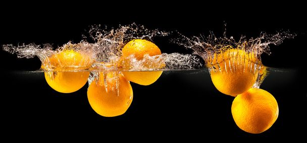 Group of fresh fruits falling in water with splash on black background - Фото, изображение