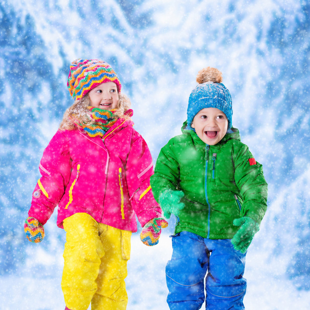 Kids playing in snowy winter park - Fotó, kép