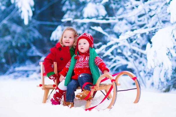 Niños divirtiéndose en un paseo en trineo en invierno
 - Foto, Imagen