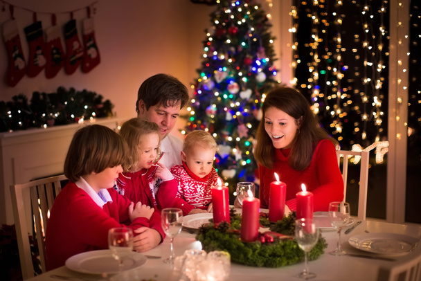 Family having Christmas dinner at fire place - Photo, Image