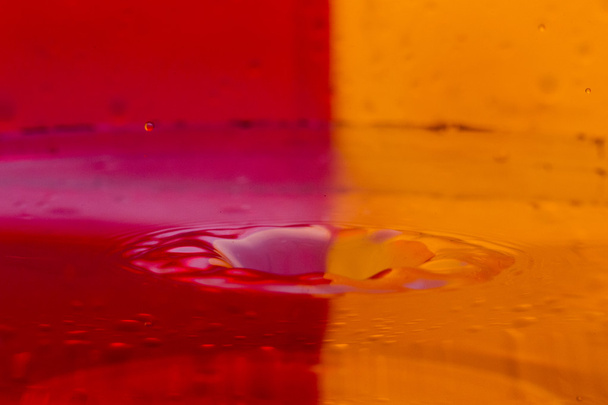 Drops, sprays, splashes of water on a colorful background - Fotografie, Obrázek