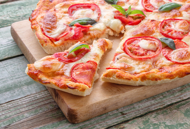 Slice of pizza on wood chopping board - Foto, immagini