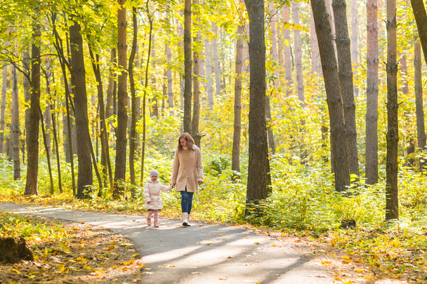 Mother and daughter walk in the autumn park - Photo, image