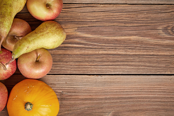 Bovenaanzicht van appelen en peren op een houten tafel - Foto, afbeelding