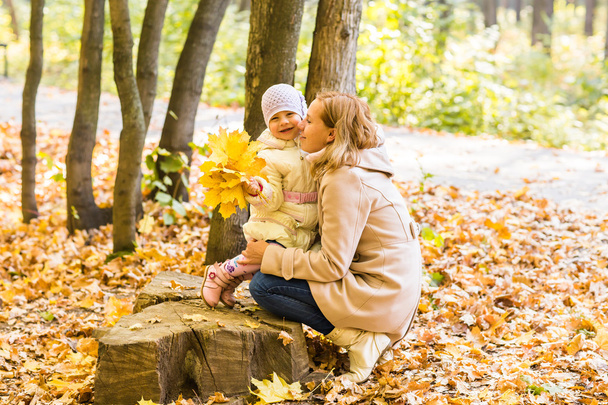 Young mother and her toddler girl have fun in autumn - Φωτογραφία, εικόνα