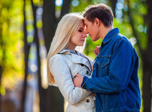 Jeune couple étreignant et ont les yeux fermés dans le parc d'automne
. - Photo, image